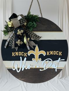 a sign that says knock knock who's out with a fleur de lys on it