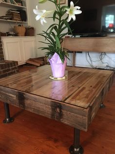 a wooden table with flowers in a vase on top