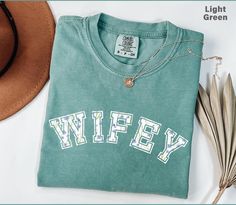 Thank you for shopping with us! Comfort Colors Wifey Shirt, Wife Shirt, Just Married Shirt, Honeymoon Shirt, Bride To Be Gift, Bridal Shower Gift, Bride Shirt, Tee HOW TO PLACE ORDER:   1. Check photos for size chart, model comparison, & color options 2. Use the drop-down menus to select your size and color   3. Select "Add to cart" - come back and repeat this process for each additional color/size variation desired  SHIRT SIZING Please note that these shirts are unisex size - so they are not wo Honeymoon Tshirts Ideas, Short Sleeve T-shirt For Honeymoon In Summer, Cotton Short-sleeved T-shirt For Honeymoon, Finally Honeymooning Shirt, Just Married Honeymoon Shirts, Married Shirt, Honeymoon Shirts, Bride Shirts, Bridal Shower Gifts