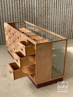 a wooden dresser with glass top and drawers