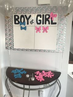 a black ironing board with pink and blue bows on it next to a sign that says boy or girl