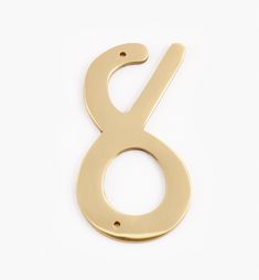 the number 8 is made out of gold metal and has been placed on a white surface