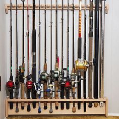 there are many different fishing rods on the wall and in the rack, all lined up