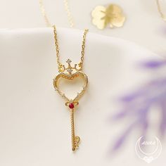 Our Rosa Key Three-Way Necklace features a crowned heart-shaped key pendant with a round ruby gemstone at the center and a white topaz rose flower charm. The key represents unlocking one's heart while the rose flower symbolizes purity and devotion. A versatile necklace that can be worn in three ways. You can wear the heart key alone for a subtle and elegant look, the glittering rose flower alone for a more feminine look, or both the key and the flower together for a more striking look. A meaning Elegant Heart-shaped Key Jewelry, Elegant Heart-shaped Necklace With Two Keys, Valentine's Day Heart Pendant Jewelry With Two Keys, Meaningful Necklace, Goddess Jewelry, Heart Key, Heart And Key, Rose Pendant, Ruby Rose