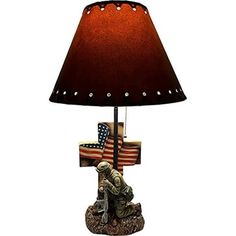 a lamp that is sitting on top of a base with an american flag and soldier figurine underneath it