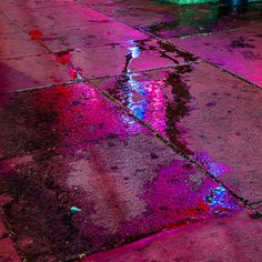 a wet sidewalk with puddles of water on it