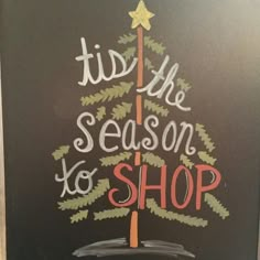 a chalk board with the words tis the season to shop written on it and a christmas tree