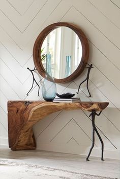 a wooden table with a mirror and vase on it