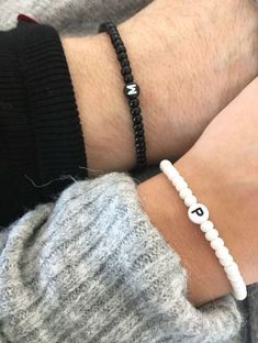 a person wearing a bracelet with the letter d on it's wrist and beaded bracelet