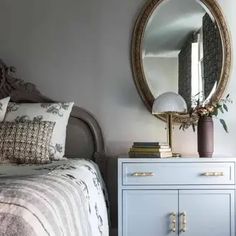 a bedroom with a bed, dresser and mirror on the wall next to each other