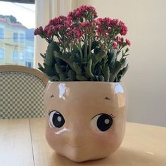 a planter with pink flowers in it sitting on a table