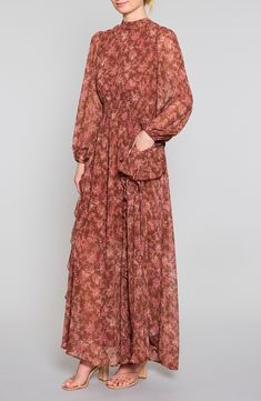 Be endlessly enchanting in the flowery chiffon maxi designed with floaty cascading ruffles and a shaping smocked waist. 58" length Adjustable back-tie closure Mock neck Long sleeves Smocked waist Partially lined 100% polyester Dry clean or hand wash, line dry Imported Chiffon Maxi Dress With Ruffle Hem For Garden Party, Feminine Chiffon Maxi Dress With Ruffle Hem, Feminine Maxi Chiffon Dress With Ruffles, Feminine Spring Georgette Maxi Dress, Bohemian Chiffon Maxi Dress With Ruffles, Spring Georgette Maxi Dress With Ruffles, Feminine Georgette Maxi Dress For Spring, Billowy Chiffon Maxi Dress For Spring, Bohemian Chiffon Dress With Ruffles