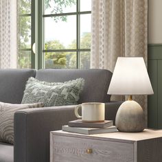 a living room scene with focus on the coffee table and lamp next to the couch