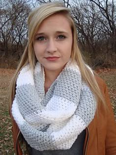 a woman wearing a white and gray knitted cowl scarf in the fall or winter