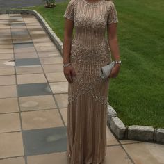 a woman in a long dress standing on a sidewalk