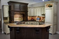 a large kitchen with an island in the middle and cabinets on both sides, along with marble counter tops