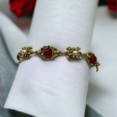 This Vintage Gold Tone Bracelet With Faux Pearl And Red Gem Detailing Adds An Elegant Touch To Any Outfit. Its 7.5" Length Ensures A Comfortable Fit. Gold Tone Link Bracelet Faux Pearl Accents Eye-Catching Red Gem Vintage Style Comfortable 7.5" Size Size: Womens 7.5" Condition: New With Box Check Out My Bundle Discount! Put Four Or More Items In Your Bundle And I'll Also Give Free Shipping! Red And Gold Wedding Jewelry, Gold And Red Accessories, Gold Bracelet Vintage, Red And Gold Jewelry Aesthetic, Gold Red Jewelry, Red Metal Bracelets For Festive Occasions, Formal Red Metal Bracelets, Vintage Red Bracelets For Party, Red Vintage Party Bracelets