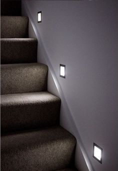 some lights that are on the side of stairs