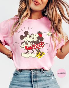 Celebrate timeless love with our "Sweet Vintage Love" tee! This charming t-shirt features an adorable vintage design of Minnie Mouse planting a sweet kiss on Mickey Mouse's cheek. Perfect for Disney fans and lovers of classic romance, this comfy, stylish shirt is a heartwarming addition to any wardrobe. Made from high-quality, soft cotton, it offers both comfort and durability, making it ideal for everyday wear or a special trip to the theme park. Spread the love and nostalgia with this delightful piece of Disney magic! Cute Pink Minnie Mouse T-shirt, Retro Pink T-shirt With Cartoon Print, Playful Graphic Print T-shirt For Valentine's Day, Pink Minnie Mouse Crew Neck T-shirt, Minnie Mouse Graphic Tee Short Sleeve, Playful Pink T-shirt For Valentine's Day, Cute Valentine's Day Graphic Print T-shirt, Cute Graphic Print T-shirt For Valentine's Day, Cute Valentine's Day Graphic T-shirt