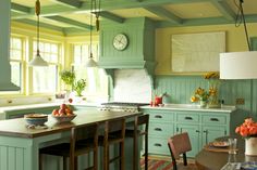 a kitchen with green cabinets and an island in front of the stove top oven is shown