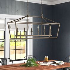 a dining room table with chairs and a chandelier hanging from it's ceiling