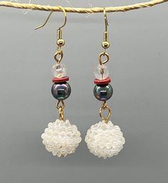 Welcome spring with these colorful beaded earrings. Handmade using shimmery white, metallic purple, and muted red beads in a variety of mediums and textures, these earrings are sure to please. Take your basic outfit to greater heights or polish off a more sophisticated ensemble with little to no effort at all. Wear them year-round for unlimited styling options.  * approx 2.5 inches * gold-colored fishhook ear wire * glass, plastic, clay Adjustable White Crystal Earrings, White Pearl Crystal Earrings For Pierced Ears, Elegant White Beaded Earrings With Czech Glass, White Pearl Crystal Earrings, Elegant White Czech Glass Beaded Earrings, White Crystal Drop Earrings With Ear Wire, Handmade White Crystal Round Earrings, Handmade White Crystal Earrings, White Pearl Earrings With Round Beads