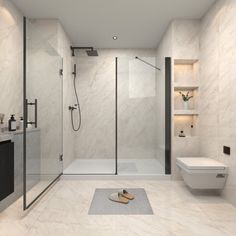 a modern bathroom with white marble walls and flooring, including a walk in shower