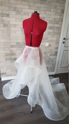 a mannequin wearing a red top and white tulle skirt with black zipper