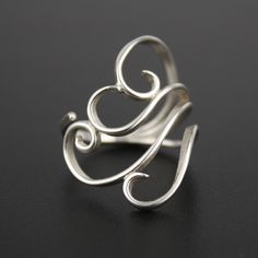 Graceful silver spirals wrap around your finger with this adjustable silver ring. Like a swirling cloud or a breath of wind, this lightweight ring is eye-catching and fun to wear. Materials: Sterling silver Fits Sizes: 5-10 Include your size as a note at checkout to have it pre-adjusted to the perfect fit for you. You may be able to (carefully!) adjust it yourself, but it would be best to have a jeweler help you! For larger or smaller sizes - please contact me about a custom order. This ring is Calder Jewelry, Dating Ring, Flatware Jewelry, Wire Jewelry Rings, Metal Jewelry Making, Silver Fits, Silverware Jewelry, Wire Jewelry Designs, Spoon Jewelry