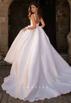 a woman in a white wedding dress standing outside