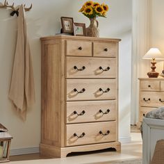 a wooden dresser sitting in a bedroom next to a bed with sunflowers on it