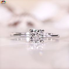 a diamond ring sitting on top of a white countertop next to a blurry background