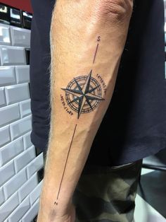 a man with a compass tattoo on his arm