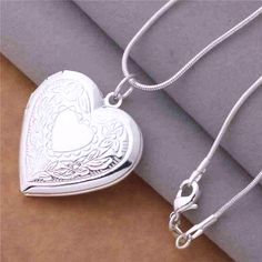 The perfect spot to keep your loved ones close. This beautiful heart shaped locket is finished in highly polished and has intricately detailed floral stamped designs along the front.The front opens on a hinge to hold photos or small momentos, a classic gift idea! Includes a smooth, 18 inch serpentine style chain. Occasions: Birthday, Holiday, Christmas, Mother's Day and Valentine's Day. Chain: 18 inch Serpentine style chain Material: Silver Plated (nickel free)brass Size: 29mm x 29mm Comes in a Silver Heart Locket, Photo Locket Necklace, Heart Photo, Sterling Silver Locket, Heart Locket Necklace, Locket Pendant Necklace, Photo Pendant, Photo Locket, Silver Plated Necklace