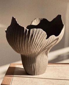 a white vase sitting on top of a wooden table