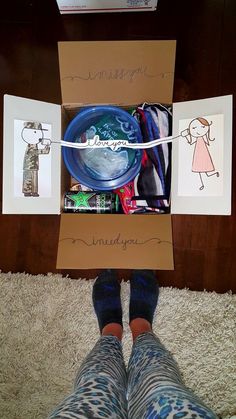 a person standing in front of a cardboard box filled with items