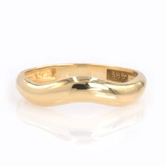 a yellow gold wedding band with the word'557'engraved on it, in front of a white background