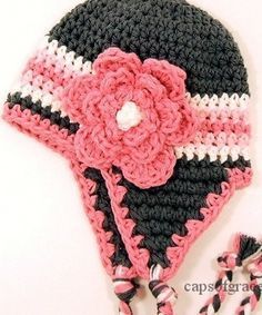 a crocheted hat with a flower on the top and two striped ties around it