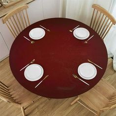 a red table with white plates and silverware on it