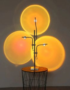 a lamp that is sitting on top of a wire stand with three balls in the background