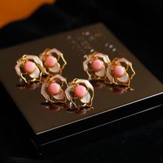 Experience the allure of royalty with our Pink Queen Conch Pearl Rose Earrings. Adorned with exquisite pink pearls sourced from the majestic Queen Conch shell, these earrings embody elegance and sophistication. The seamless blend of the lustrous pink pearls with delicate rose-shaped white Mother of Pearl petals creates a stunning visual harmony. Crafted with 925 sterling silver, these earrings are a testament to impeccable craftsmanship and enduring beauty. Embrace the regal charm of our Pink Qu Elegant Pink Pearl Jewelry, Luxury Pink Earrings For Wedding, Luxury Pink Jewelry With Matching Earrings, Elegant Pink Gold Flower Jewelry, Elegant Pink Flower-shaped Jewelry, Luxury Pink Round Earrings, Blush Luxury Formal Jewelry, Feminine Pink Pearl Earrings For Party, Feminine Pink Pearl Drop Earrings