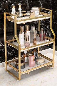 a bathroom shelf with cosmetics and lotion on it in front of a marble wall