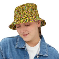 Unleash your wild side with our eye-catching yellow bucket hat, adorned with striking black and multi-colored leopard spots. This hat combines a sunny, cheerful background with a playful and fierce leopard print, perfect for adding a touch of fun and flair to your summer wardrobe. The bold pattern is sure to make a statement wherever you go, whether you're hitting the beach or strolling through the city. Features: Material: High-quality, durable fabric that is lightweight and comfortable for all Trendy Yellow Wide Brim Bucket Hat, Yellow Bucket Hat With Short Brim For Outdoor, Trendy Yellow Beach Bucket Hat, Trendy Yellow Bucket Hat For Beach, Trendy Yellow Bucket Hat For Summer, Yellow Short Brim Bucket Hat For Outdoor, Fun Yellow Sun Hat With Curved Brim, Trendy Yellow Sun Hat With Curved Brim, Yellow Wide Brim Bucket Hat For Outdoor