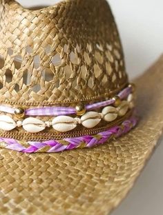 Did someone say coastal cowgirl summer??? Beach day? Country concert? Girls trip? Our handmade cowgirl hats are the PERFECT accessory for any outfit! The Kohana (or Little Flower) Hat is a tan straw cowgirl hat decorated with purple & gold ribbon, plain cowrie shells, & gold chain. Gold Straw Hat For Beach With Short Brim, Adjustable Gold Straw Sun Hat, Pink Bohemian Straw Hat For Beach Season, Beige Straw Hat For Western-themed Summer Events, Gold Fedora Straw Hat For The Beach, Gold Brimmed Straw Hat For The Beach, Gold Brimmed Straw Hat For Beach, Pink Bohemian Straw Hat For Beach, Gold Summer Straw Hat For The Beach