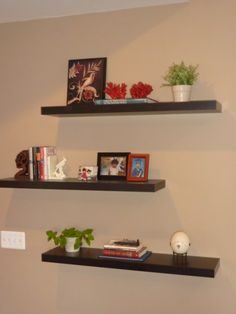 two black floating shelves with books and pictures on them