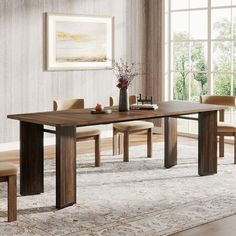 a dining room table with chairs and a rug on the floor in front of it