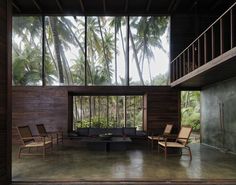 a living room filled with furniture and lots of windows next to palm tree covered walls