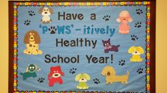 a bulletin board with dogs and paw prints on it that says have a paws - lively healthy school year