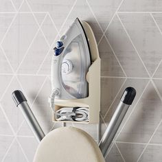 an ironing board and some tools on a wall