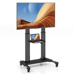 a flat screen tv sitting on top of a metal stand next to a laptop computer